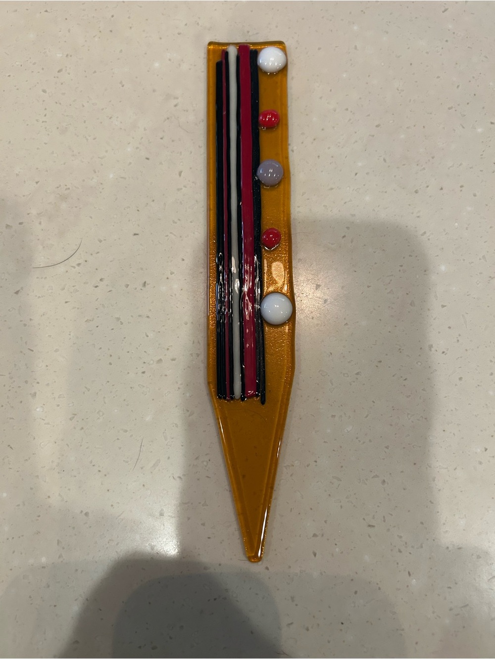 Handmade Glass Plant Stake Amber glass with red, black, white accents.